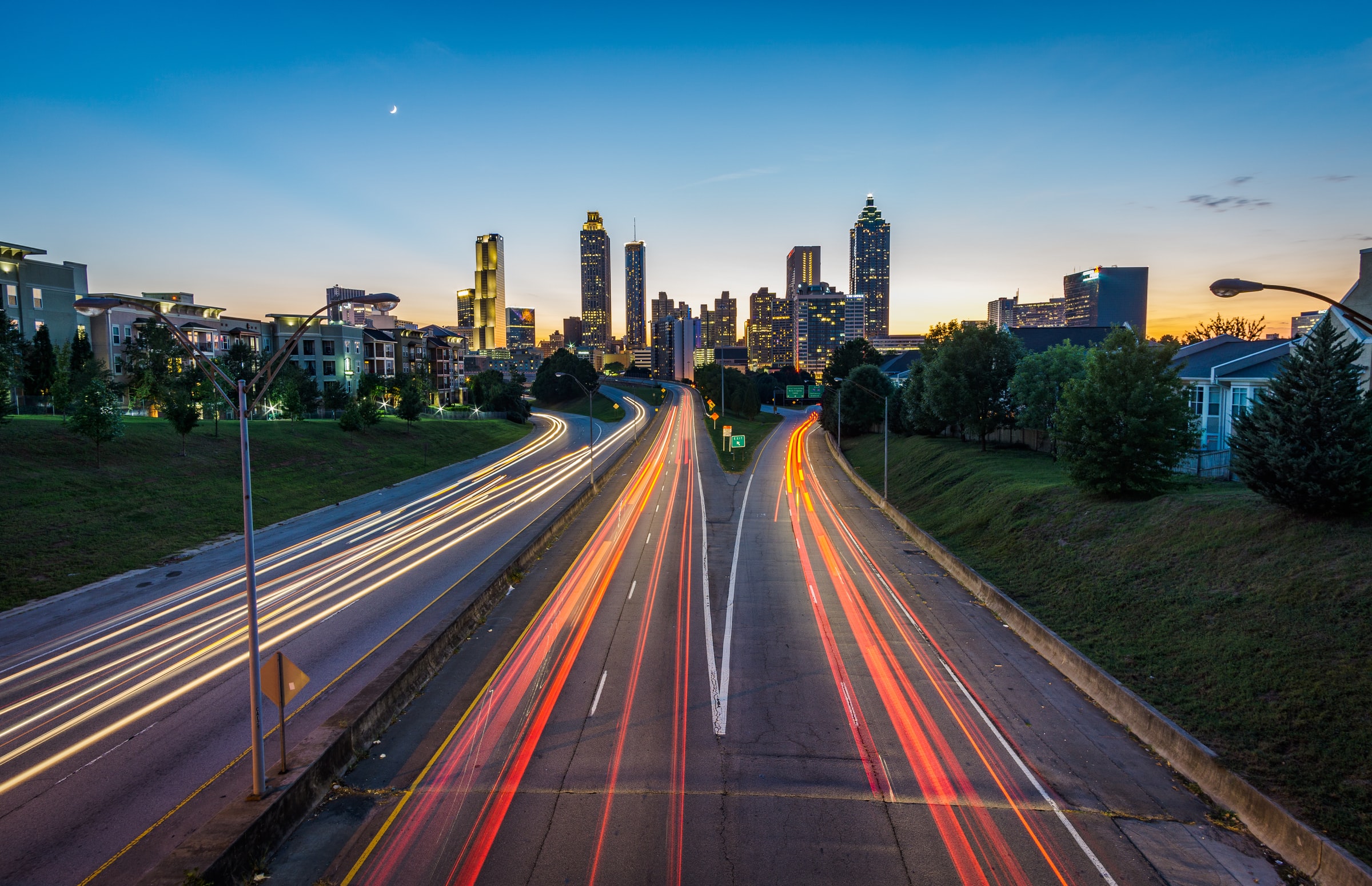 Image of the Atlanta skyline at sunset with light trails on the highway.