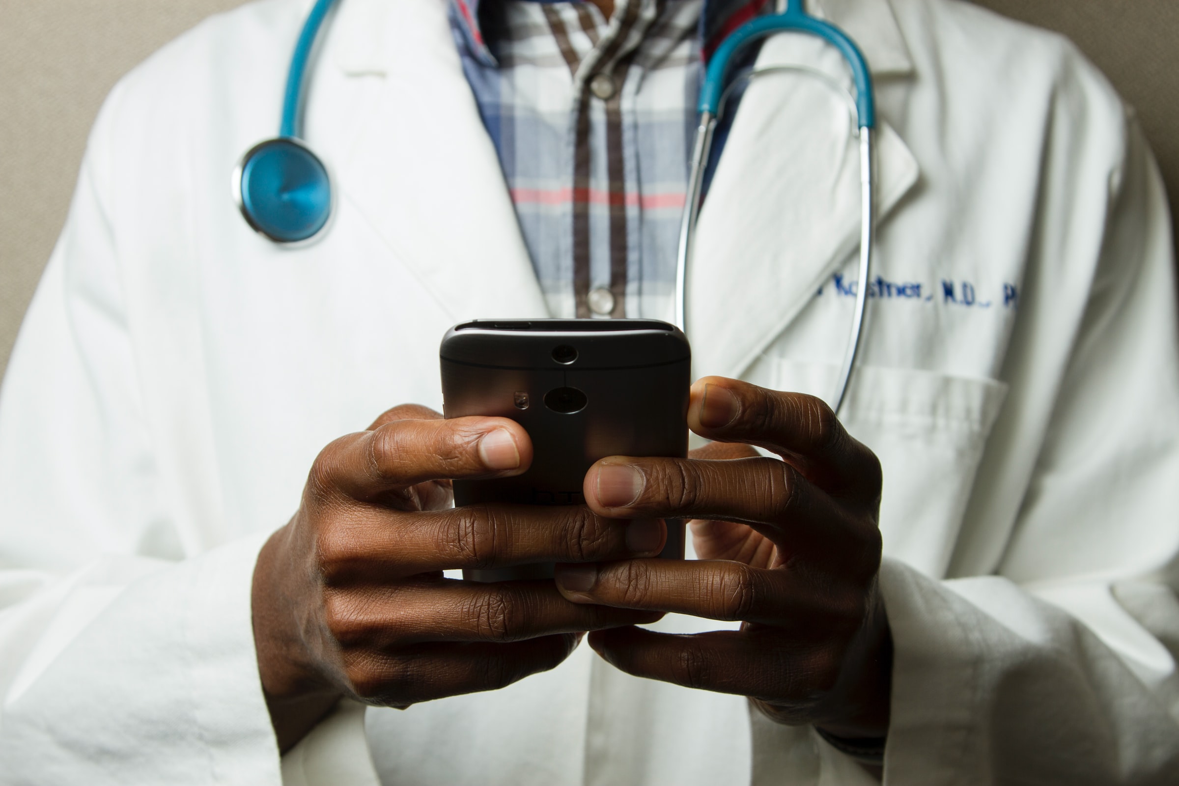 Photo of a doctor holding a smartphone.