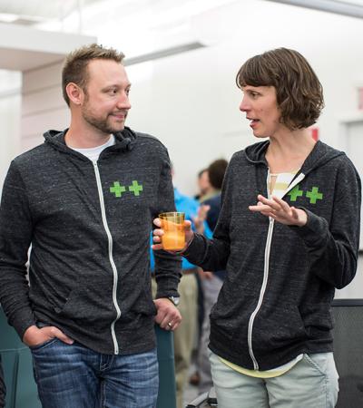 Two people in conversation wearing ++ jackets