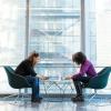 Two women are sitting at a table, seemingly engaged in a conversation.